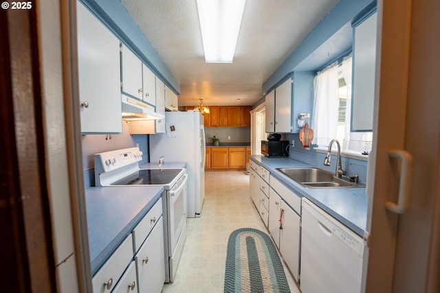 1630 SW Riverhill Dr, Hermiston, OR 97838 - kitchen with white appliances, a sink, under cabinet range hood, light floors, and white cabinets