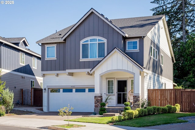 view of front of property with an attached garage, a shingled roof, and fence