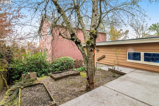 view of home's exterior featuring fence and a vegetable garden