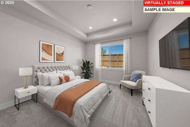 bedroom featuring a raised ceiling and light carpet