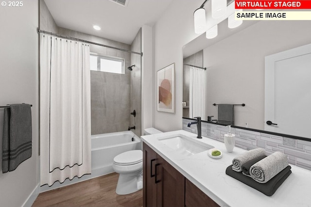 full bathroom with shower / tub combo with curtain, toilet, vanity, hardwood / wood-style flooring, and backsplash