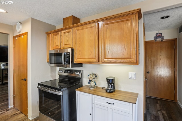 4055 NE 13th Ter, Gresham, OR 97030 - kitchen with stainless steel appliances, wood finished floors, butcher block countertops, a textured ceiling, and brown cabinetry