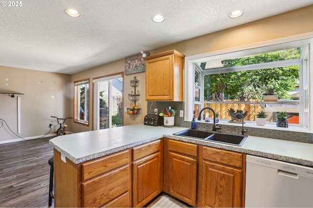 4055 NE 13th Ter, Gresham, OR 97030 - kitchen with dishwasher, a sink, a textured ceiling, wood finished floors, and a peninsula