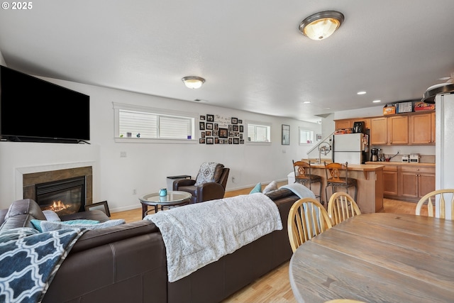 12631 SE Division St, Portland, OR 97236 - living room with a glass covered fireplace, recessed lighting, light wood-style flooring, and baseboards