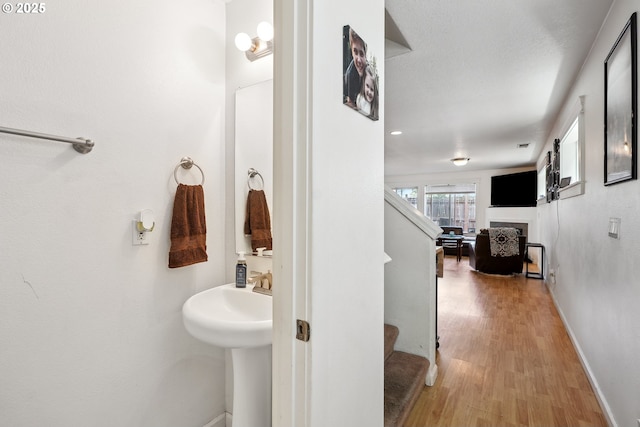12631 SE Division St, Portland, OR 97236 - bathroom featuring wood finished floors, a fireplace, and baseboards