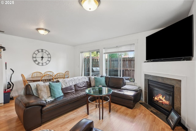 12631 SE Division St, Portland, OR 97236 - living room featuring visible vents, light wood-type flooring, and a fireplace with flush hearth
