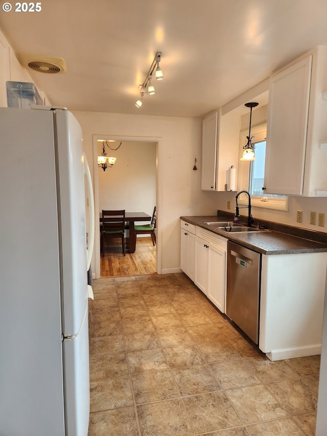 kitchen with sink, decorative light fixtures, white refrigerator, stainless steel dishwasher, and white cabinets