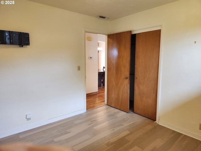 unfurnished bedroom featuring a closet and light hardwood / wood-style flooring