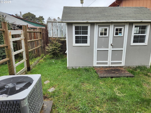 view of outbuilding featuring central AC unit and a lawn