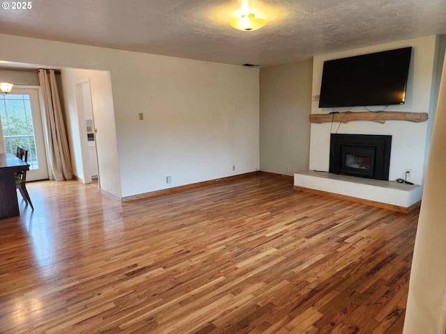 unfurnished living room with hardwood / wood-style floors and a textured ceiling