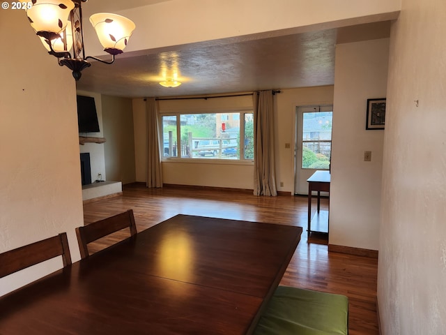 unfurnished dining area with hardwood / wood-style flooring, a chandelier, and a textured ceiling