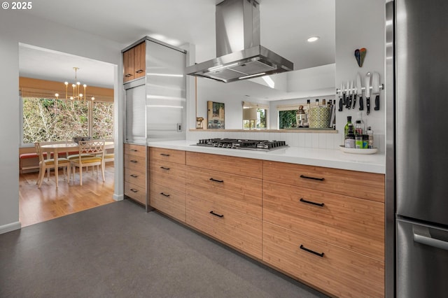 2631 SW Sherwood Dr, Portland, OR 97201 - kitchen featuring appliances with stainless steel finishes, island exhaust hood, a notable chandelier, and plenty of natural light
