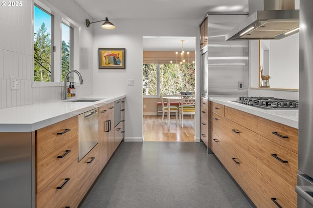 2631 SW Sherwood Dr, Portland, OR 97201 - kitchen featuring baseboards, a sink, ventilation hood, a chandelier, and stainless steel appliances