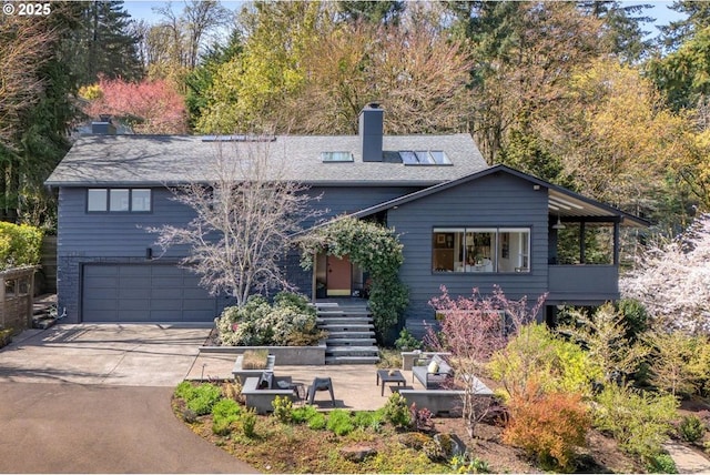 2631 SW Sherwood Dr, Portland, OR 97201 - view of front facade featuring an attached garage, driveway, and a chimney