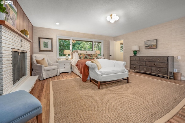 2631 SW Sherwood Dr, Portland, OR 97201 - bedroom with a fireplace, a textured ceiling, and wood finished floors