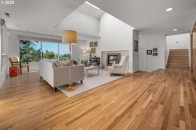2631 SW Sherwood Dr, Portland, OR 97201 - living room featuring visible vents, a tiled fireplace, light wood-style floors, recessed lighting, and stairs