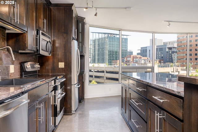 1500 SW 5th Ave Unit 703, Portland, OR 97201 - kitchen featuring stainless steel appliances, a view of city, dark brown cabinetry, dark stone countertops, and tasteful backsplash