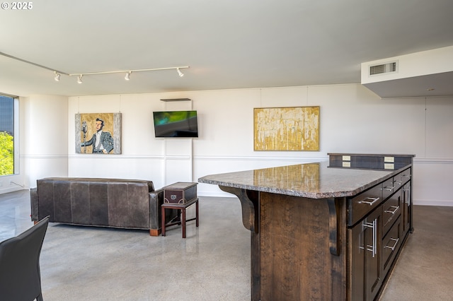 1500 SW 5th Ave Unit 703, Portland, OR 97201 - kitchen featuring dark brown cabinets, dark stone counters, finished concrete flooring, and open floor plan