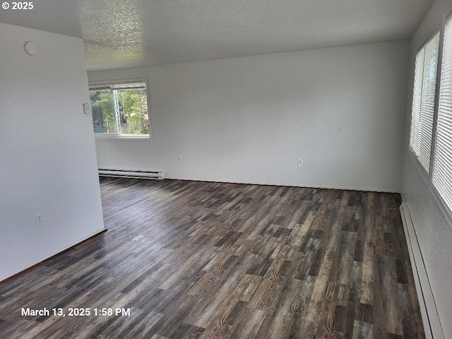 unfurnished room featuring a baseboard heating unit, wood finished floors, baseboard heating, and a textured ceiling
