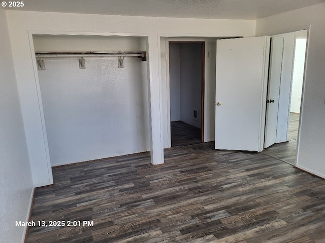 unfurnished bedroom featuring dark wood finished floors, visible vents, and a textured ceiling