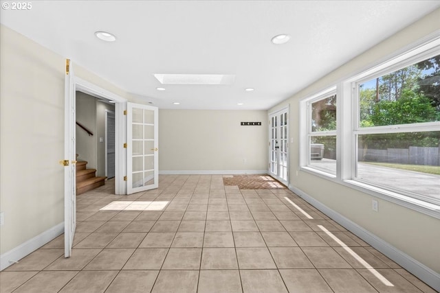 620 Sky Ln, Forest Grove, OR 97116 - spare room featuring a skylight, stairway, french doors, light tile patterned floors, and recessed lighting