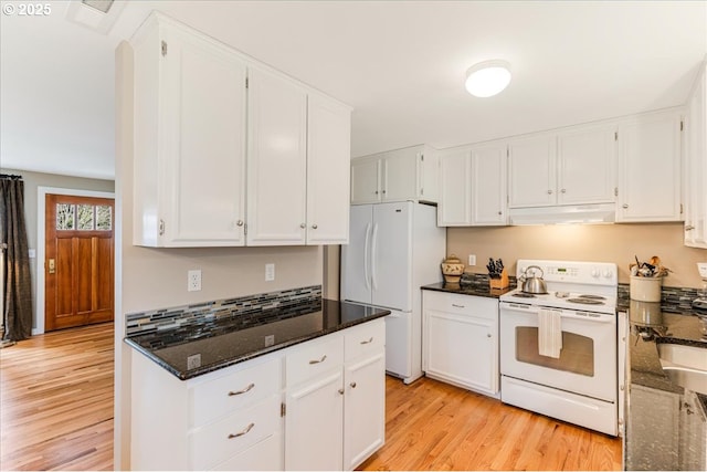 kitchen with white cabinetry, white appliances, under cabinet range hood, and dark stone counters