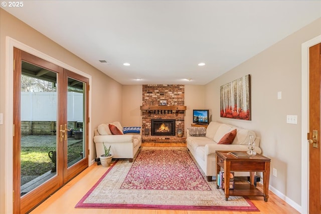 living area with visible vents, recessed lighting, light wood-style floors, a fireplace, and baseboards