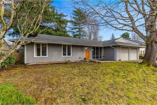 ranch-style home with a front yard, a garage, and fence