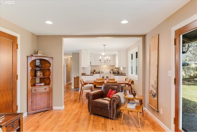 interior space with recessed lighting, baseboards, light wood-type flooring, and an inviting chandelier