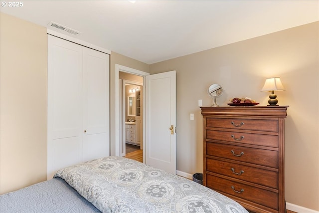 bedroom featuring baseboards, visible vents, and a closet