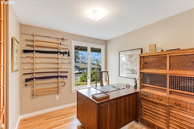 home office featuring baseboards and light wood finished floors