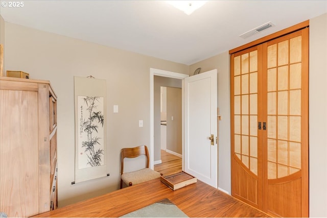 foyer with visible vents, french doors, and wood finished floors