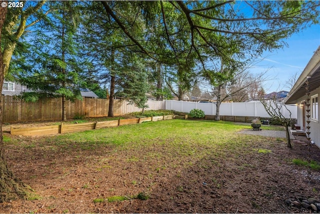 view of yard with a fenced backyard and a vegetable garden