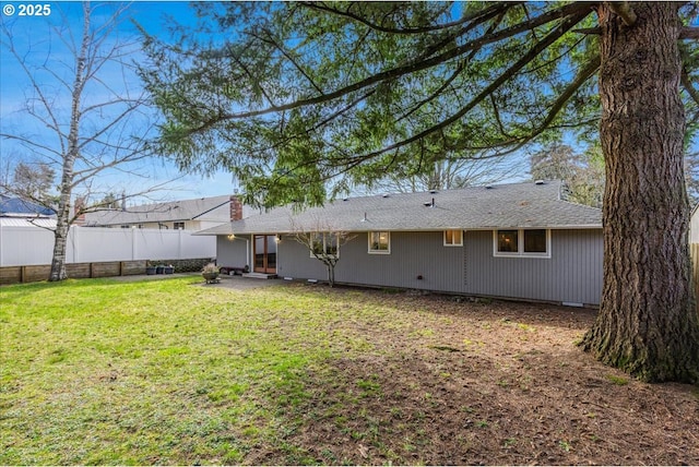 back of house with a yard and fence