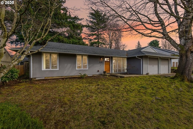 single story home with a lawn, a garage, and fence