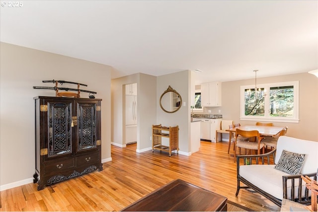 living area with light wood-type flooring and baseboards