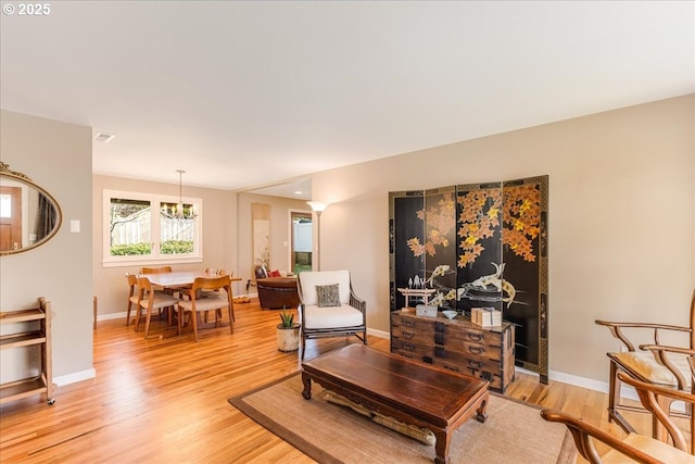 living room with light wood-style flooring, visible vents, and baseboards