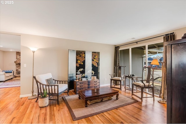 sitting room featuring baseboards and light wood finished floors