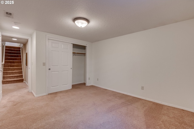 7067 N Dwight Ave, Portland, OR 97203 - unfurnished bedroom with light carpet, a textured ceiling, and a closet