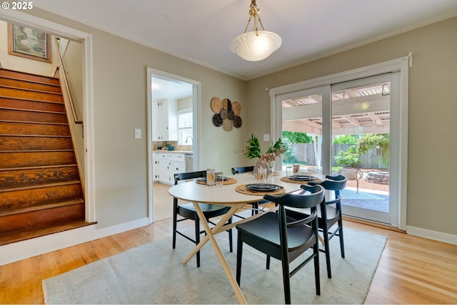 7067 N Dwight Ave, Portland, OR 97203 - dining space featuring light wood finished floors, stairs, and ornamental molding