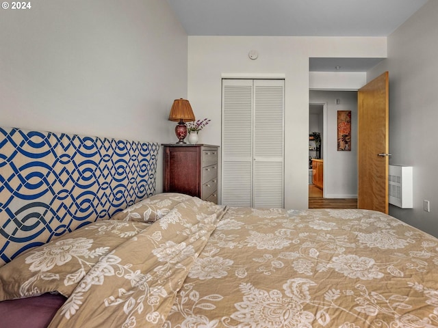 bedroom featuring heating unit and a closet