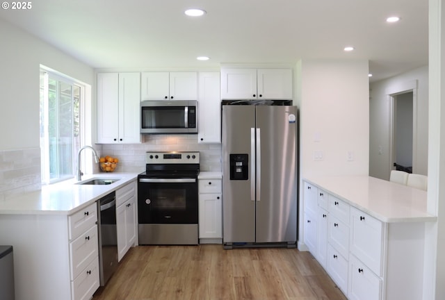 550 NE 20th Dr, Gresham, OR 97030 - kitchen with stainless steel appliances, a sink, a peninsula, tasteful backsplash, and recessed lighting