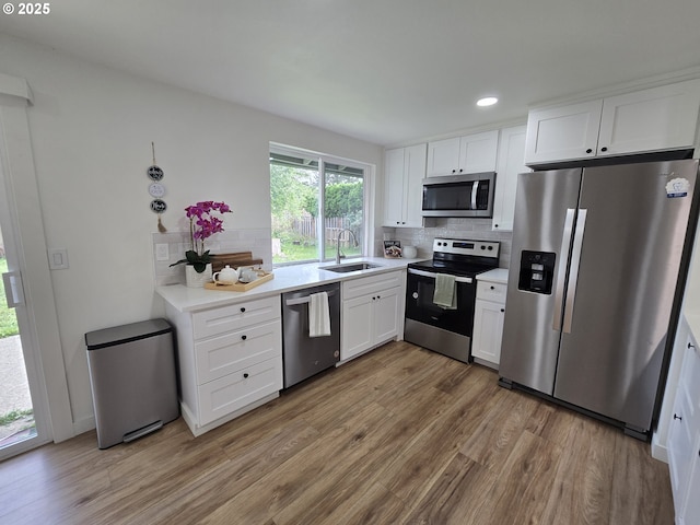 550 NE 20th Dr, Gresham, OR 97030 - kitchen featuring stainless steel appliances, light wood finished floors, tasteful backsplash, white cabinets, and recessed lighting