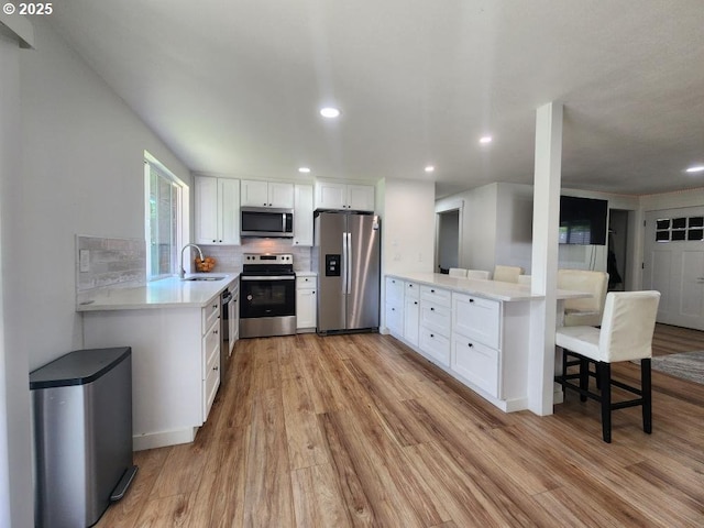 550 NE 20th Dr, Gresham, OR 97030 - kitchen with stainless steel appliances, light wood-type flooring, light countertops, white cabinetry, and recessed lighting