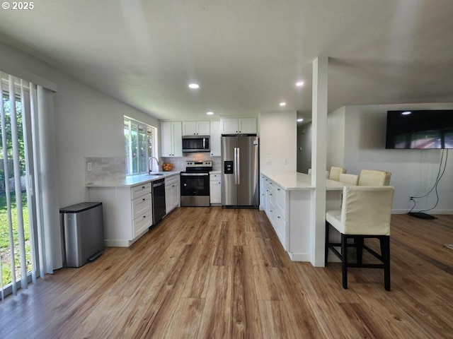 550 NE 20th Dr, Gresham, OR 97030 - kitchen with stainless steel appliances, light countertops, wood finished floors, and recessed lighting