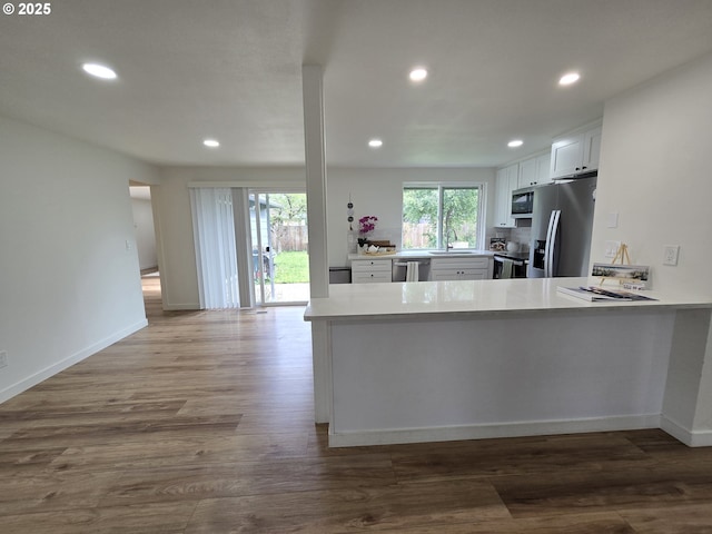 550 NE 20th Dr, Gresham, OR 97030 - kitchen with appliances with stainless steel finishes, recessed lighting, light countertops, white cabinets, and wood finished floors