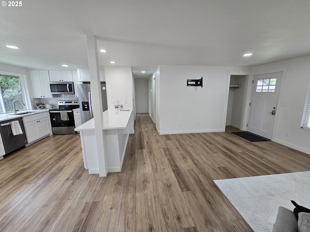 550 NE 20th Dr, Gresham, OR 97030 - kitchen with appliances with stainless steel finishes, light countertops, white cabinetry, recessed lighting, and plenty of natural light