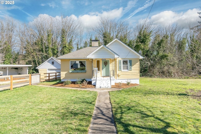 bungalow-style house featuring a front yard, fence, and a chimney