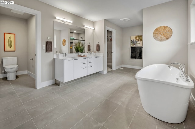 full bathroom featuring double vanity, tile patterned floors, a sink, and a soaking tub