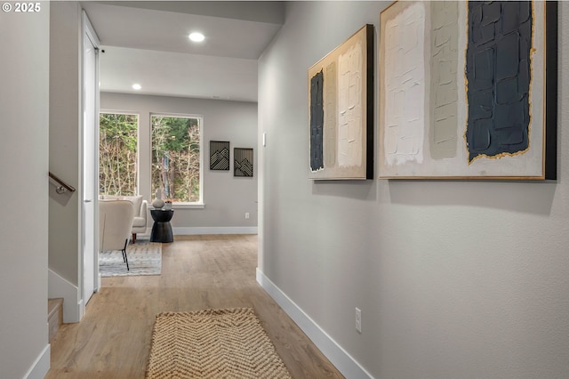 hall with baseboards, recessed lighting, and light wood-style flooring